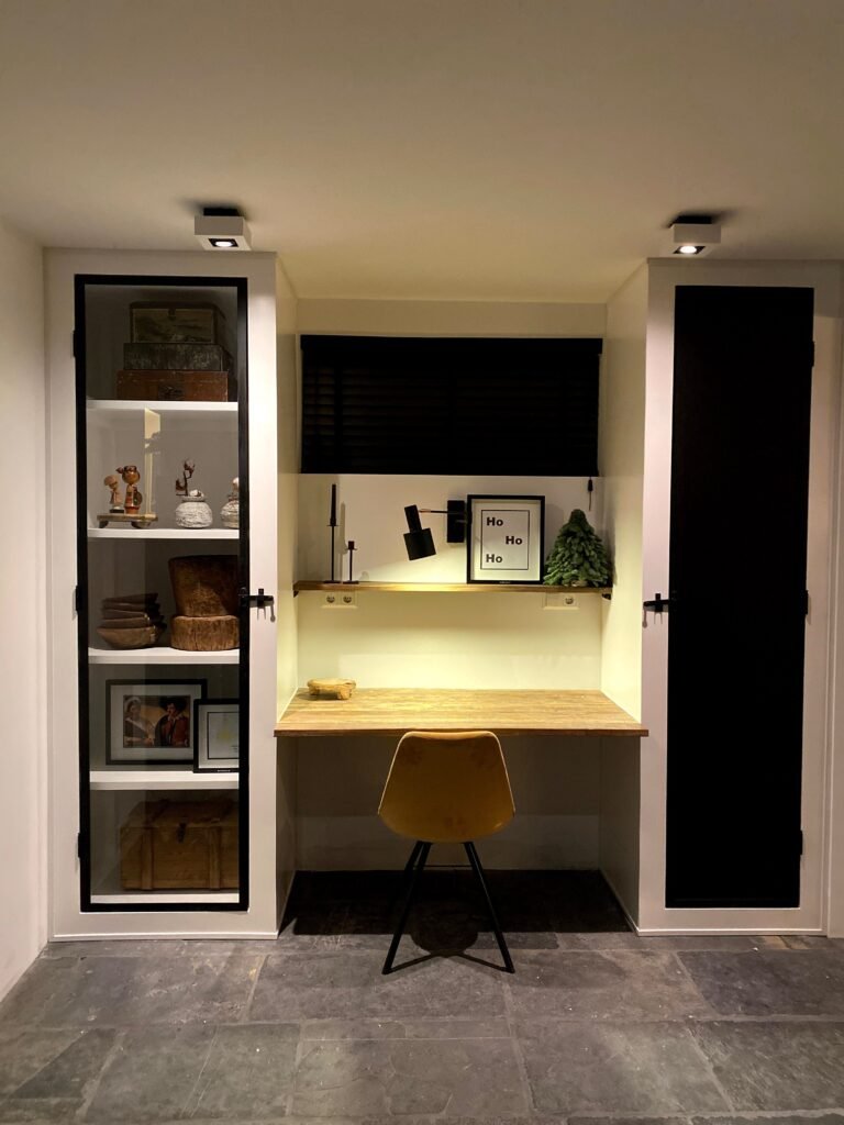 Compact built-in home office desk between storage cabinets with a yellow chair