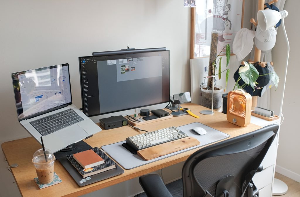 Home office desk with an ergonomic chair, laptop stand, and computer monitor